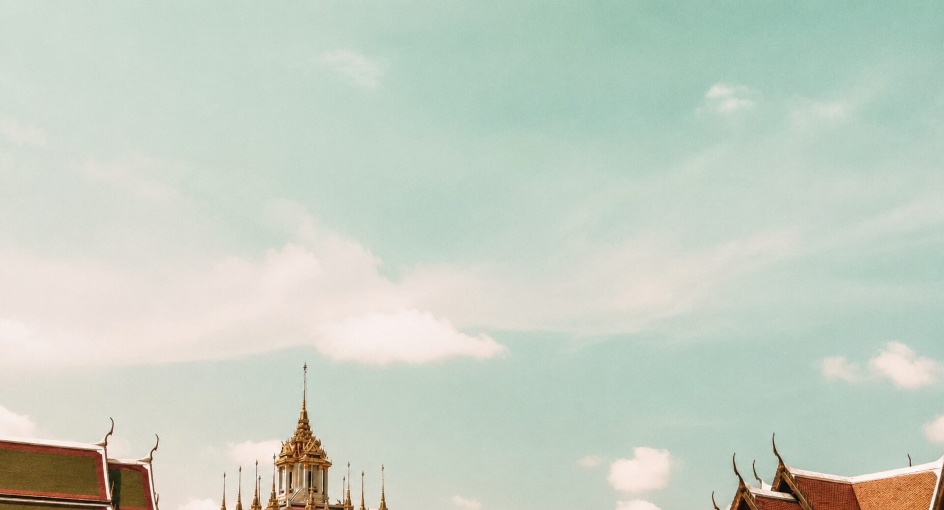 Thai temple rooftops against a soft sky